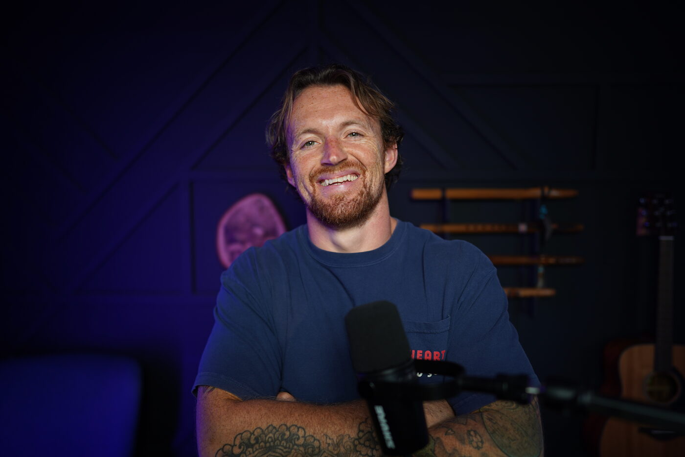 Ste laughing behind a microphone in his studio